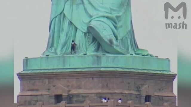 Женщина забралась на статую свободы