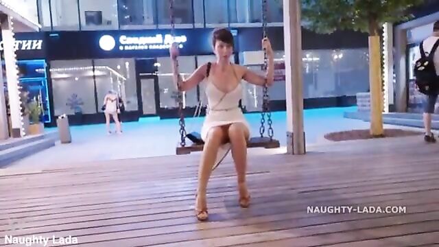 Naughty lada walks in the city wearing a see-through dress